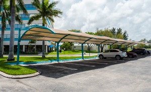 Square shade structure over parking lot row.